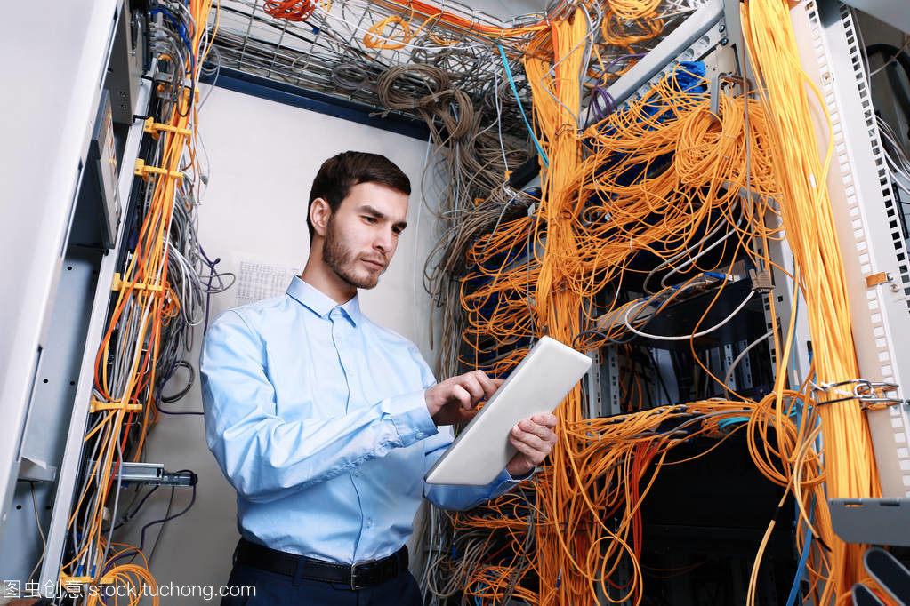 年輕的工程師在服務(wù)器房間里的網(wǎng)絡(luò)工程挑戰(zhàn)與成長